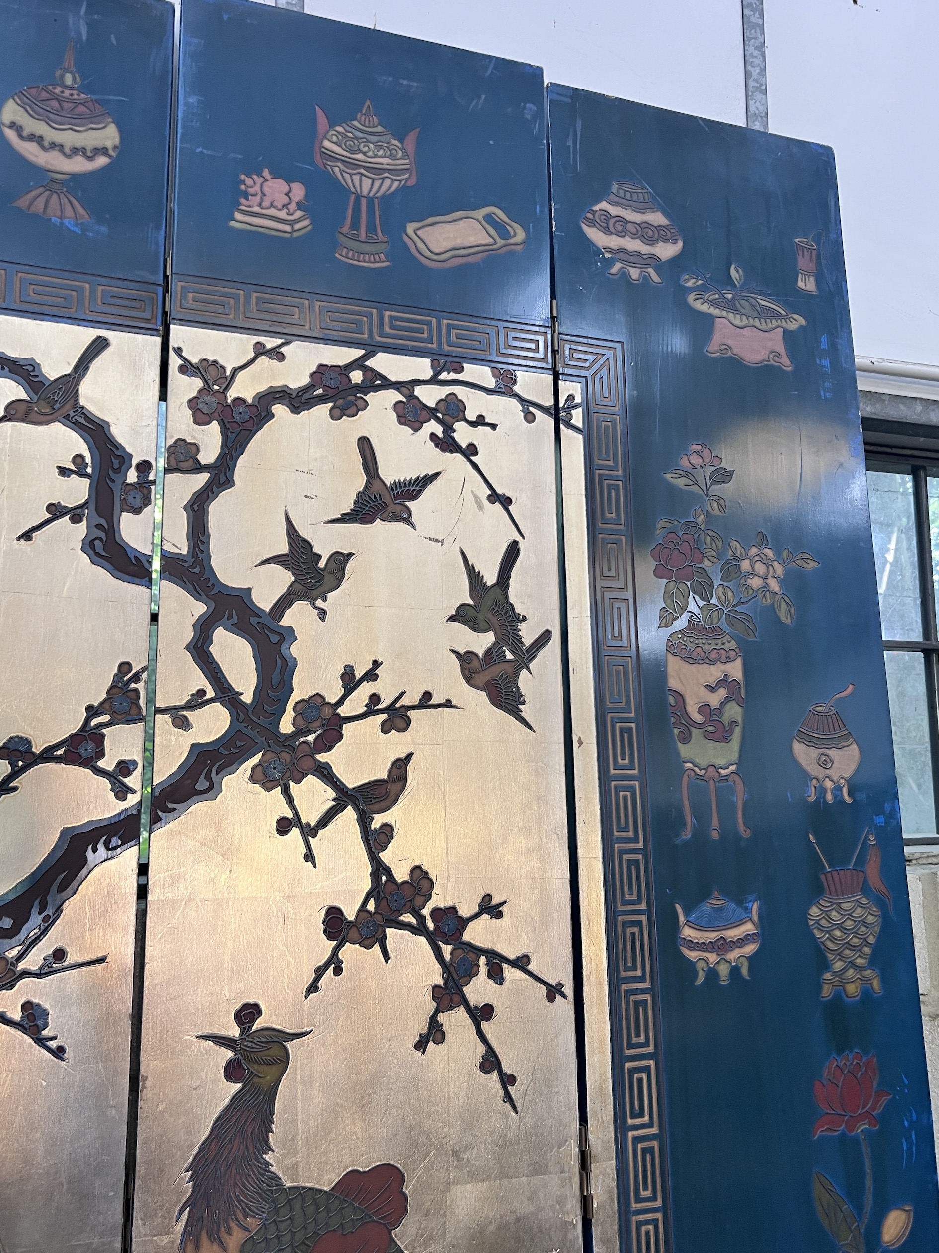 A Chinese lacquered eight fold screen decorated with exotic birds among flowering trees, each panel width 40cm, height 244cm (no fixing clips)